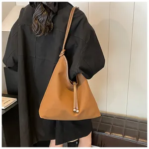 Detailed view of large brown hobo tote bag worn on shoulder by model from the back
