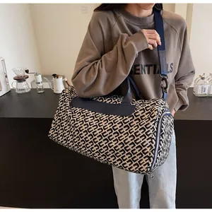 Grand sac de voyage avec motif géométrique porté par un mannequin dans un cadre moderne