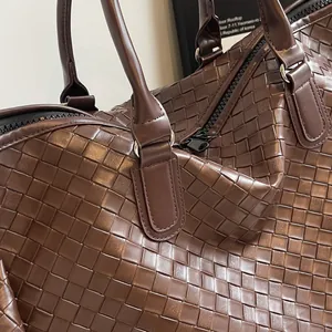 Close-up macro view of the intricate brown woven texture on a fashion travel bag