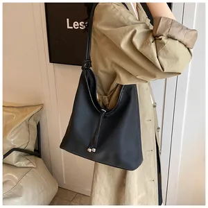 Side view of large black minimalist tote bag with knot strap and metallic beads