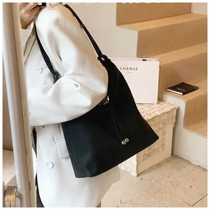 Side view of a black minimalist large capacity tote bag on a woman's shoulder