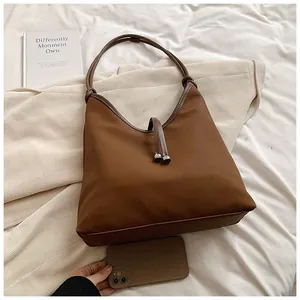 Large capacity brown minimalist tote bag shown with daily lifestyle accessories detail