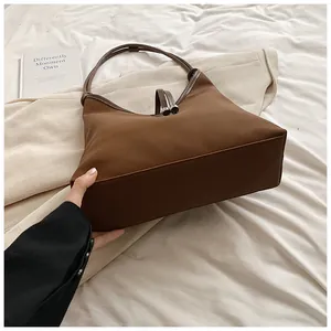 Detailed side view of minimalist brown nylon tote bag with smooth texture and sturdy base