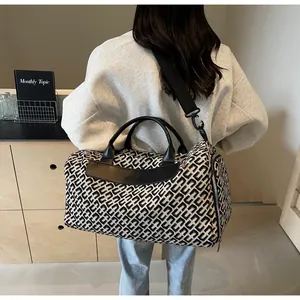 Grand sac de voyage à motif géométrique noir et blanc porté par un mannequin