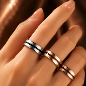 Macro view of three brushed metal rings with colored drip oil lines on model's hand