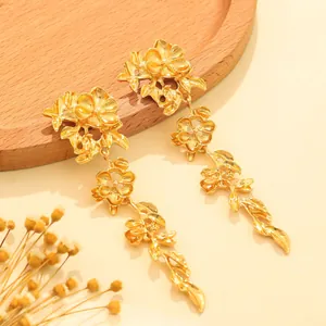 Detailed view of elegant gold-toned floral dangling earrings with intricate metal petals
