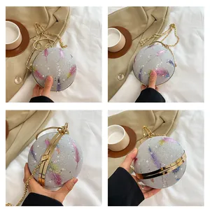 Detailansicht der runden Abendtasche mit Federprint und goldener Kette