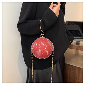 Detailansicht einer roten kugelförmigen Abendtasche mit Federdruck und goldener Kette