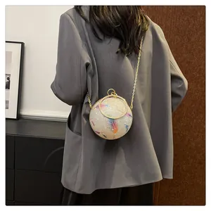Detailansicht eines runden Abendtasche mit bunten Federn und goldener Kette von hinten