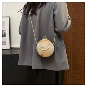 Elegante kugelförmige Abendtasche mit Federprint und goldener Kette, am Model getragen