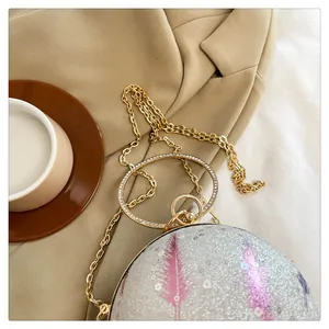 Detailansicht einer stilvollen runden Abendtasche mit Silberglitzer und Kristallgriff.