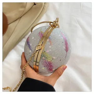 Nahaufnahme der silbernen kugelförmigen Abendtasche mit Federdruck und Goldkette.