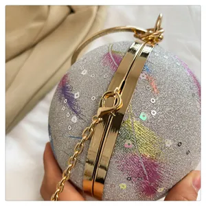 Nahaufnahme einer runden Abendtasche mit feiner Glitzerstruktur und goldener Kette