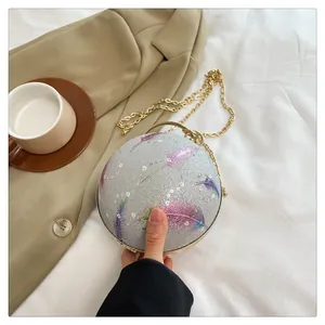 Detaillierte Ansicht der runden Glitzer-Abendtasche mit Federdruck und Goldkette