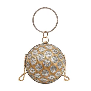 Detaillierte Ansicht der kugelförmigen Abendtasche mit goldenem Blumenmuster und Griff