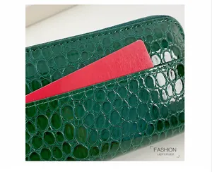 Detailansicht der grünen Handtasche aus Leder mit Krokodilprägung und praktischem Kartenfach