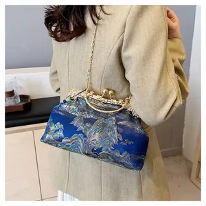 Detailansicht einer eleganten Abendtasche mit chinesischer Stickerei und Goldkette