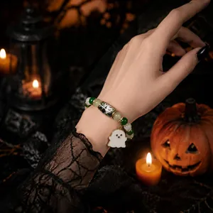 Close-up of a Halloween beaded bracelet with a ghost charm in a spooky setting