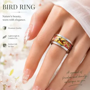 Detailed close-up of a stainless steel ring with colorful bird and flower patterns.