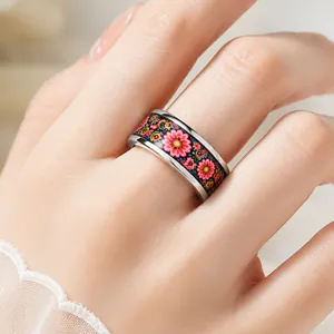 Elegant stainless steel ring with vibrant colorful floral pattern shown on hand