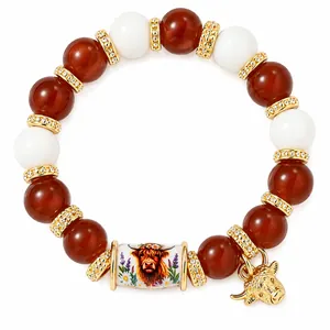 Handmade stretch beaded bracelet featuring red beads and a unique Highland cow charm