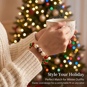 Detail view of a festive Christmas beaded bracelet with tree charm on a woman's wrist.