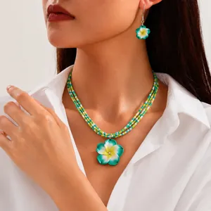 Detailansicht eines handgefertigten Schmucksets mit Plumeria-Blüten auf einem Modell