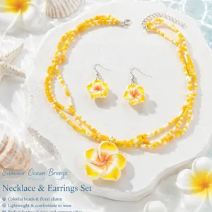 Nahaufnahme des böhmischen Plumeria Halsketten und Ohrring Sets mit leuchtend gelben Perlen