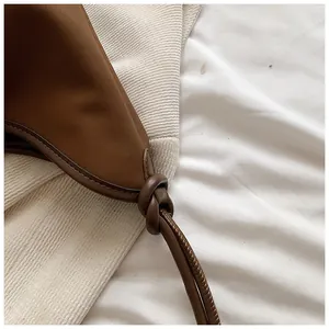 Close-up of the knotted handle on a minimalist brown tote bag for modern women