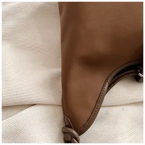 Detailed view of the brown matte leather texture and fine stitching on a tote bag
