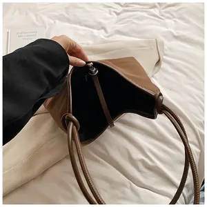 A detail view showing the spacious interior of a brown minimalist leather tote bag