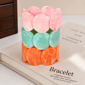 Detailed macro view of stacked irregular round resin bracelets with colorful marble texture