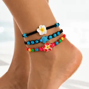 Vue détaillée de gros plan sur des bracelets de cheville bohèmes à fleurs et perles