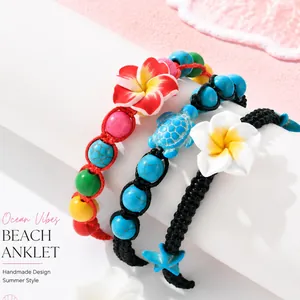 Gros plan de bracelets de cheville d'été faits main avec fleurs en argile et perles