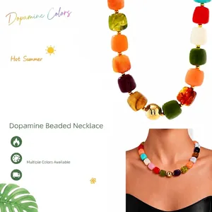 Vibrant multi-colored acrylic beaded necklace with gold bead detail worn by model