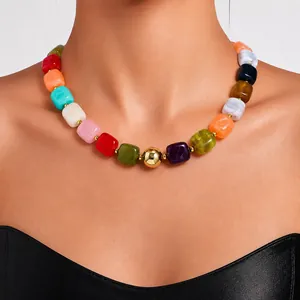 Close-up detail of a vibrant multicolored acrylic chunky bead necklace worn by a model