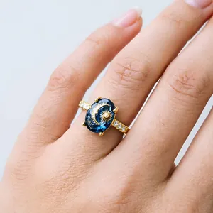 Close-up of a vintage celestial ring with sun and moon pattern on a deep blue stone.