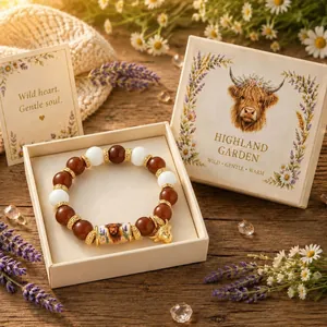 Close-up detail of handmade beaded bracelet featuring a highland cow charm in a gift box