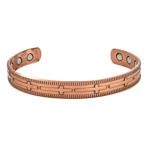 Macro view of vintage copper magnetic bracelet with engraved cross patterns for health.