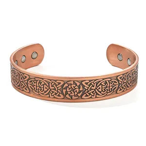 Close-up of vintage copper cuff bracelet featuring intricate Celtic knot patterns and magnets