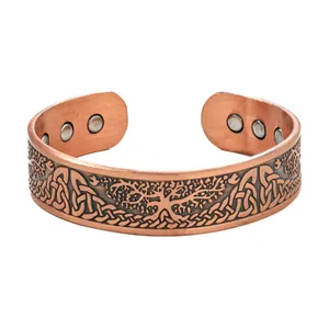 Macro view of copper magnetic cuff bracelet featuring an engraved Tree of Life design