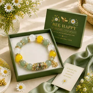 Detailed view of the bee themed beaded lucky bracelet in green gift box packaging.