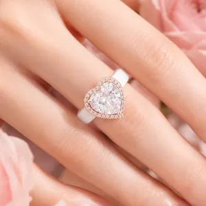 Primer plano de un anillo de silicona blanca con circón en forma de corazón y halo rosa