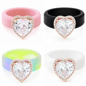 Detalle de cuatro anillos de silicona con brillantes circonitas en forma de corazón de colores.