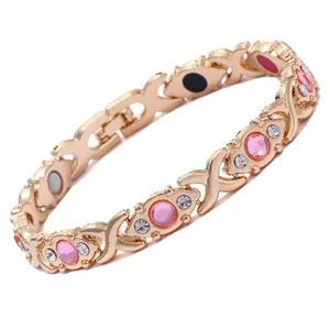 Elegant gold plated magnetic therapy bracelet with pink stones and X-link design.