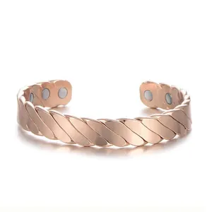 Detail view of rose gold magnetic therapy alloy cuff bracelet with striped texture.