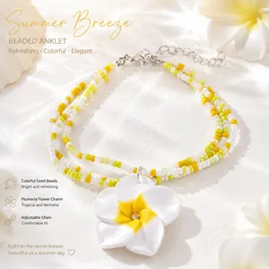 Vue détaillée du charme de fleur de plumeria sur un bracelet de cheville en perles colorées