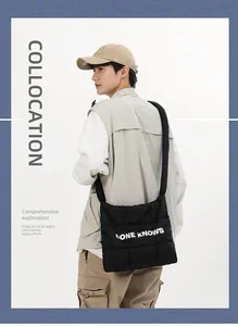 Gros plan sur un sac bandoulière élégant en nylon noir matelassé avec lettrage blanc