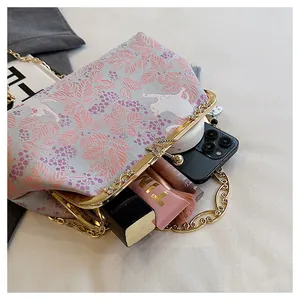 Detail view of embroidered evening bag with cat pattern showing interior capacity