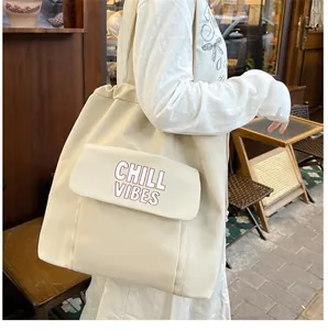 Gedetailleerd beeld van de crème nylon draagtas met Chill Vibes-print op een model